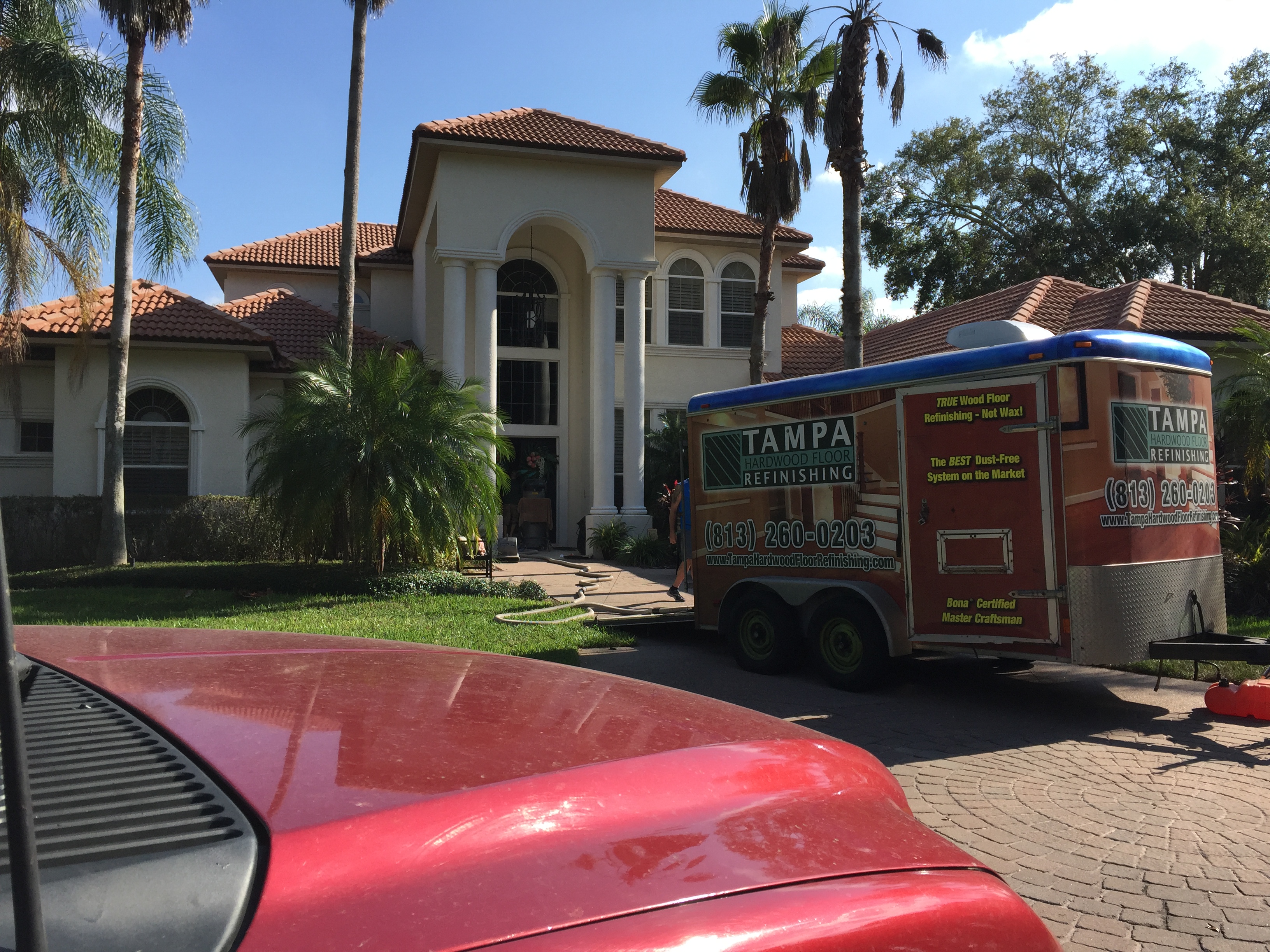 A red car parked in front of a house.